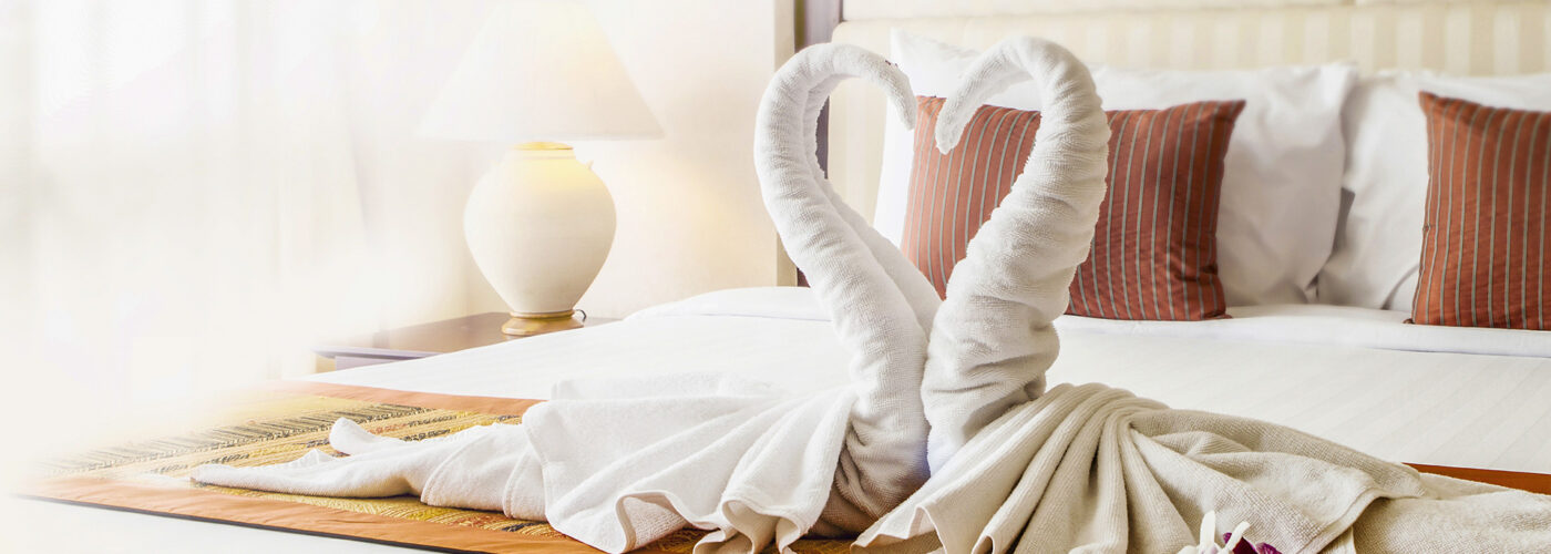 hotel bed with a swan towel