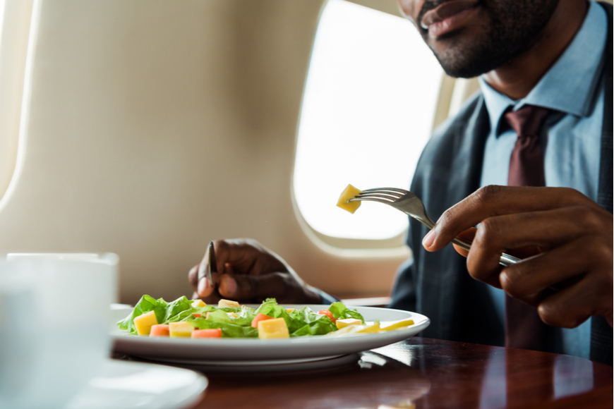 Man eating salad on plane