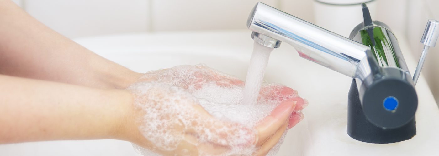 Woman washing hands to avoid norovirus