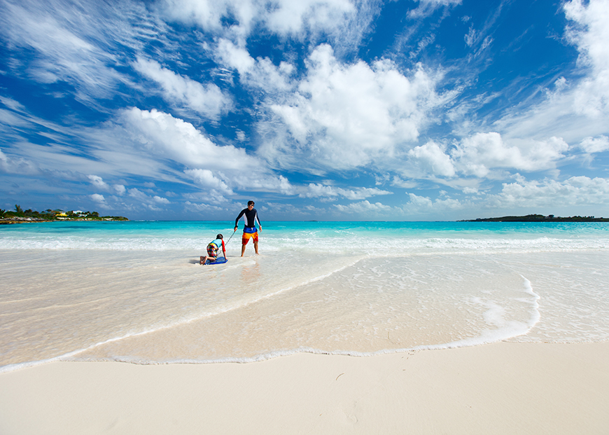 father and child on beach in bahamas