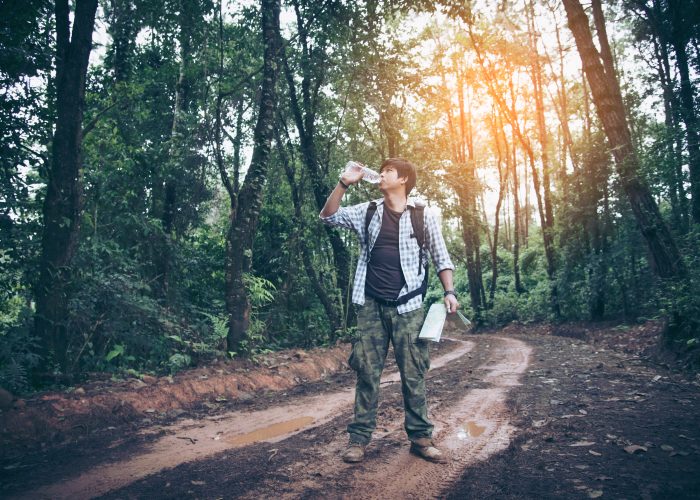 hiker drinking water in the woods