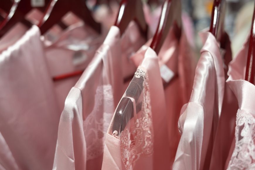 pink silk blouses on hangers.