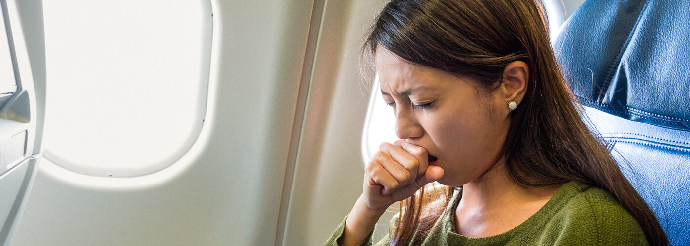 Woman feeling sick inside air plane coughing