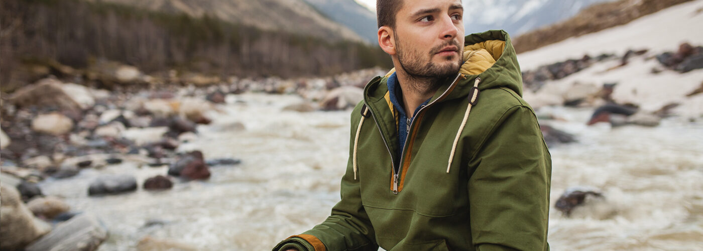 sitting by the river, wild nature, winter vacation, hiking, traveling, backpacker, warm clothes, anorak