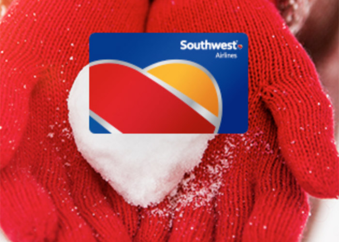 Hands in red gloves holding a Southwest Gift Card