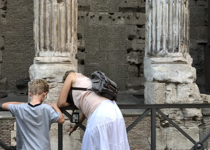 Tour guide points to ancient street level in Rome