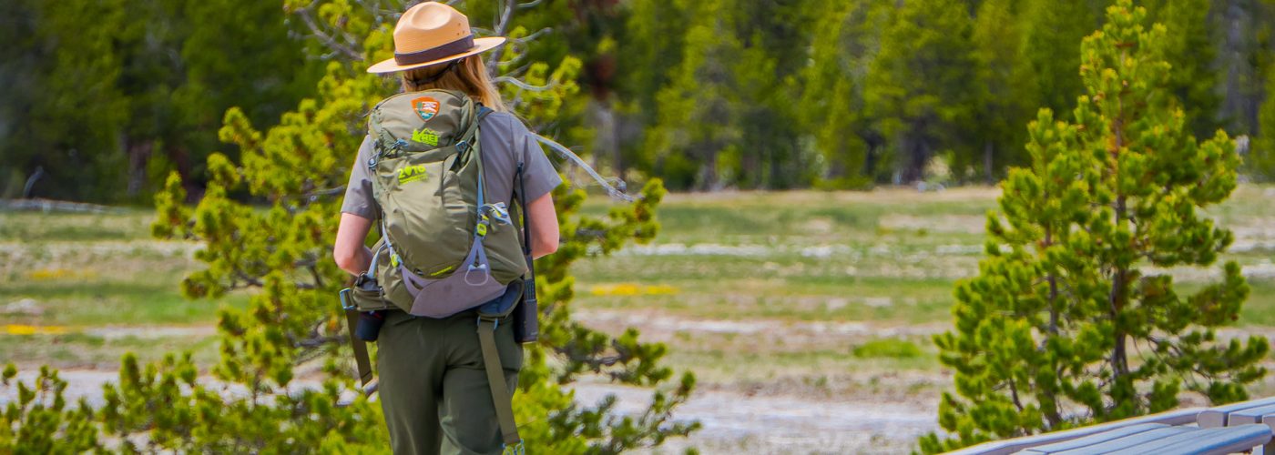 female national park ranger walking in park