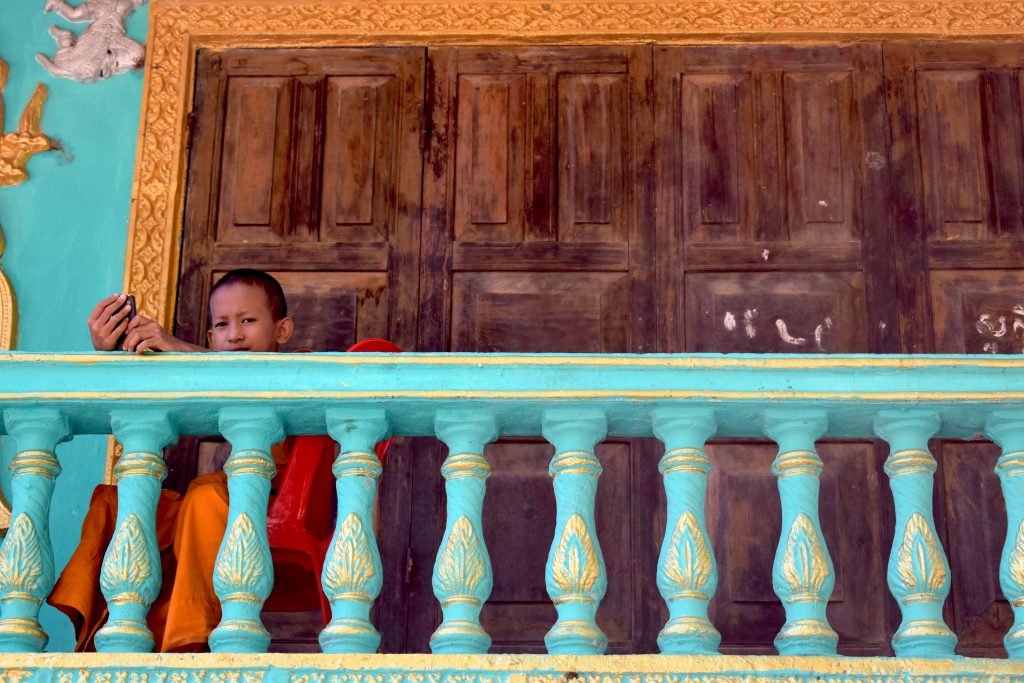 a young monk looks out over the temple