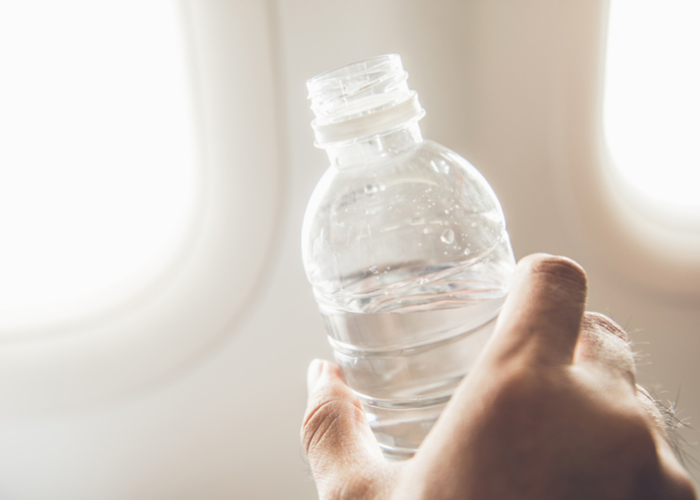 hand holding water bottle on airplane