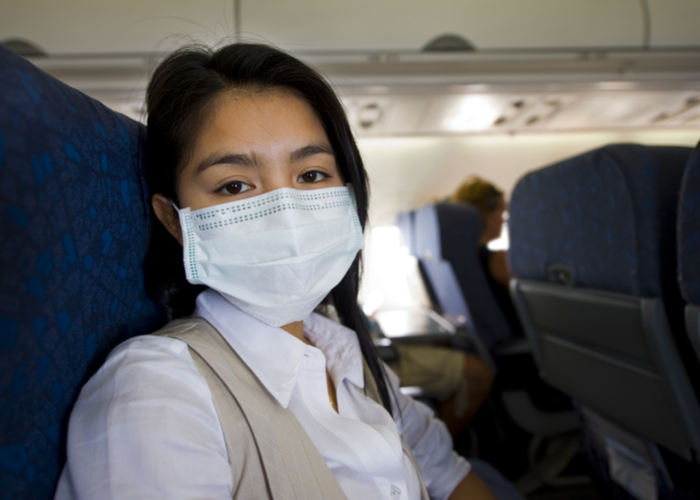 person with face mask on airplane