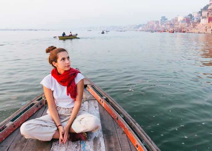 woman wearing scarf on a boat in the ganges river in India