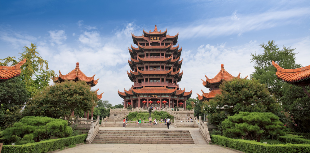 a tall multi-storied chinese tower sits at the top of three flights stairs