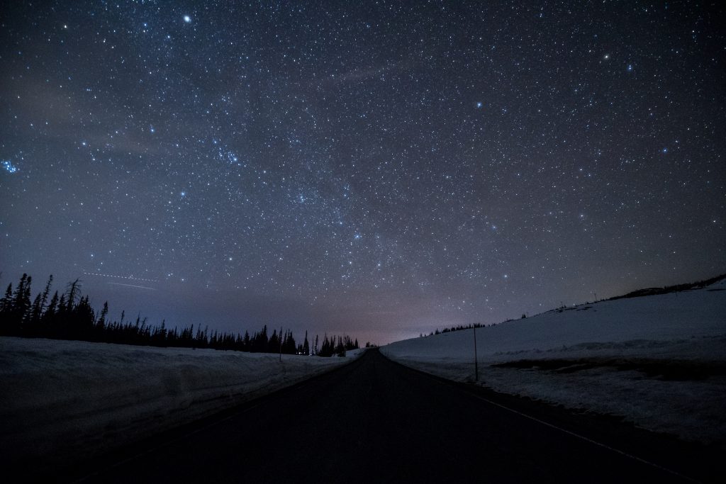 highway on dark road with bright sky stars