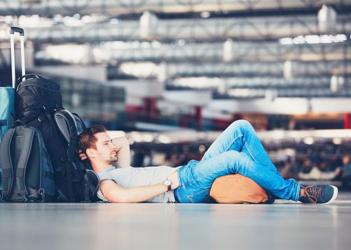 E.U. flight delays rule traveler waiting in airport.