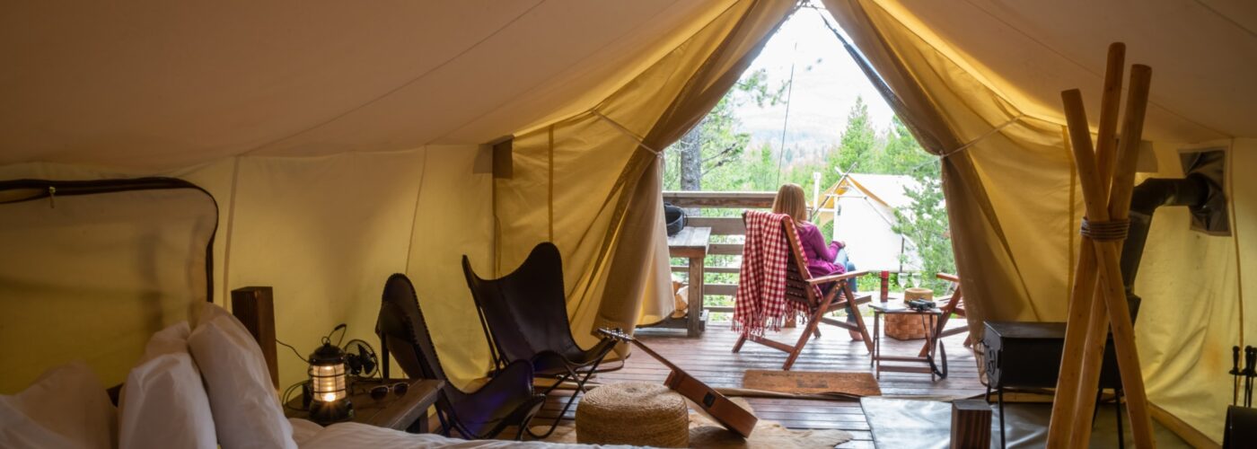 woman-sitting-outside-luxury-tent-on-glamping-trip-in-glacier-national-park