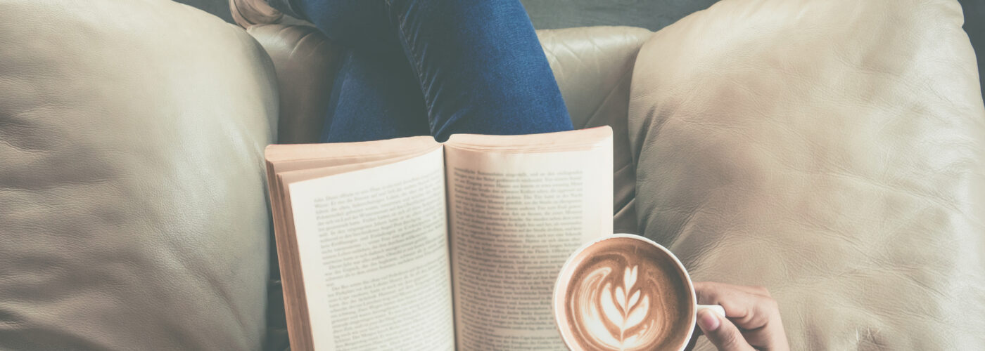 person reading book with coffee