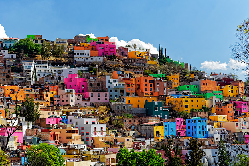 Colorful neighborhood perched on a hill with sky and cloud background in the beautiful, historic city of Guanajuato, Gto., Mexico