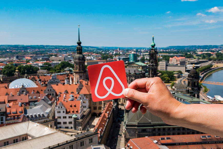 Travel around the world with airbnb. logo airbnb and city on background. home concept.