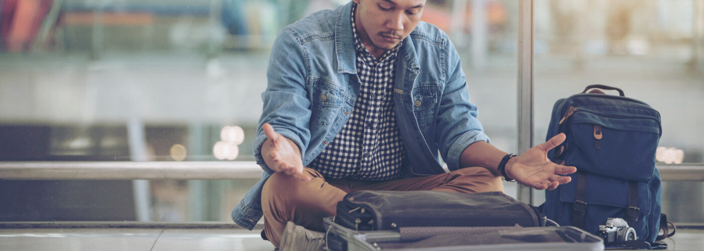 man looking at empty suitcase worried