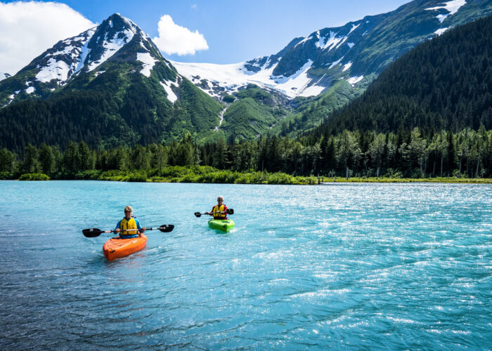 two people kayak in front of a glacier in anchorage alaska