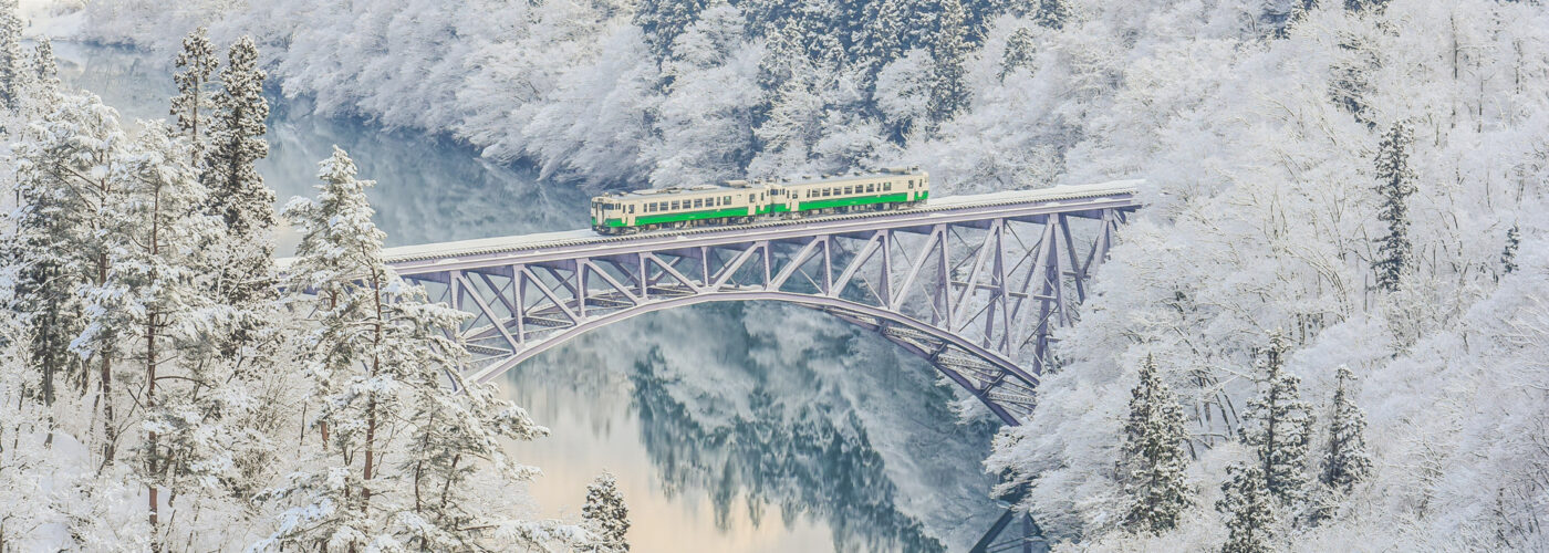 train passing over bridge in japan winter backdrop