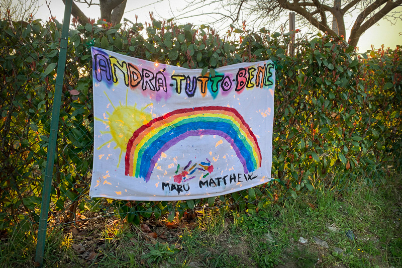 drawings of rainbows with the phrase “Andrà tutto bene