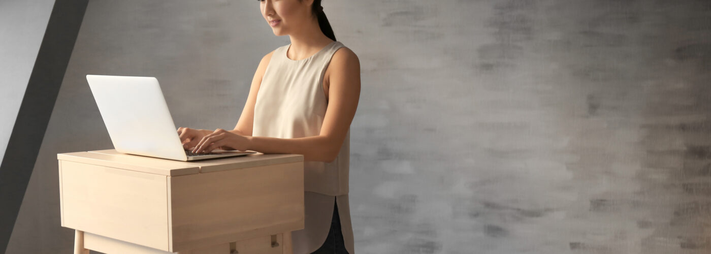 woman typing at standing desk