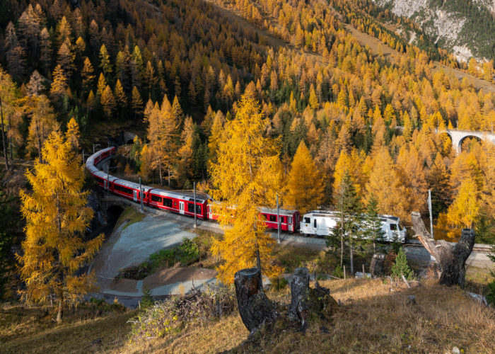 Train winding through mountains and forest in fall