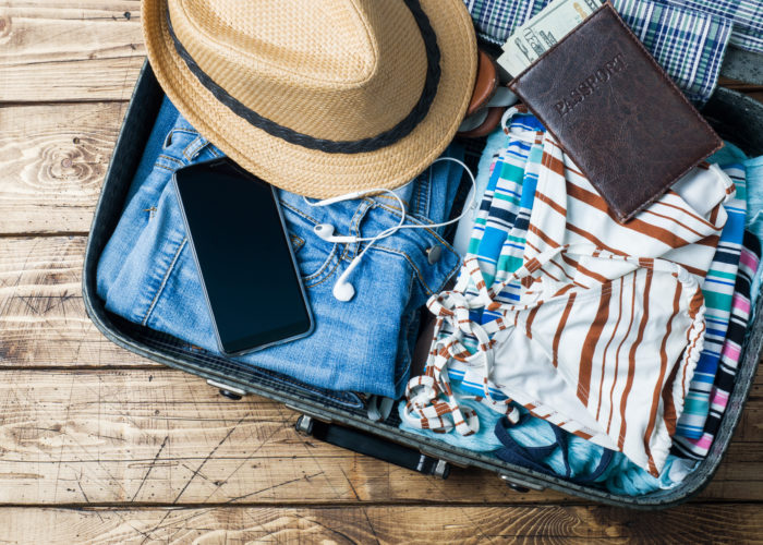 Open suitcase with summer travel clothes