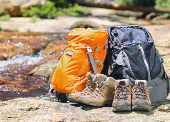 Two backpacks and some boots by a stream in nature