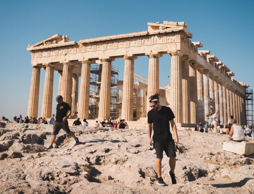 Men walking around Greek ruins