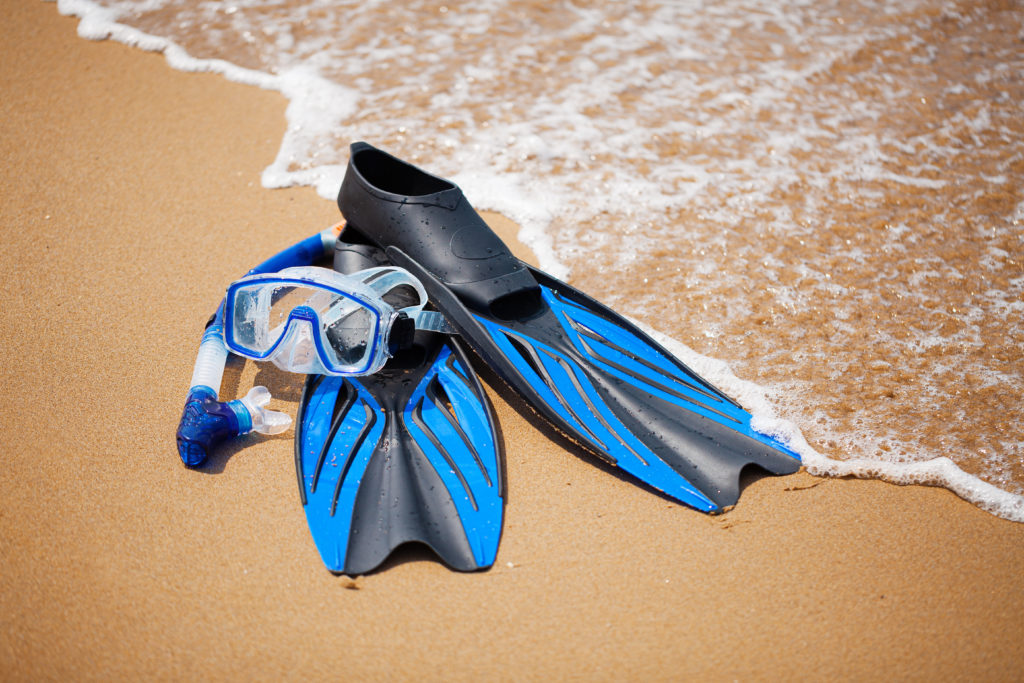 Blue flippers and snorkel mask at the beach
