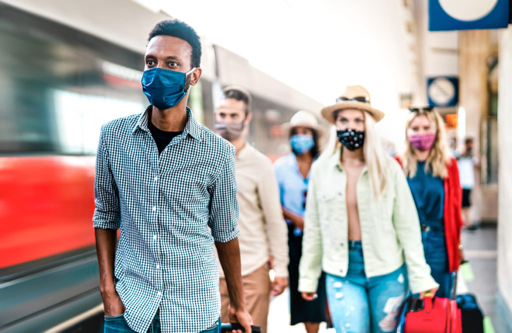 Group wearing face masks exits train
