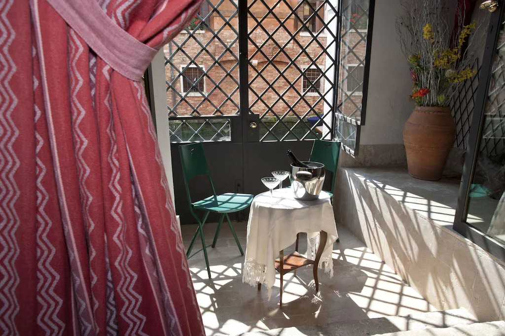 An enclosed patio space with champagne on a small table in Venice, Italy