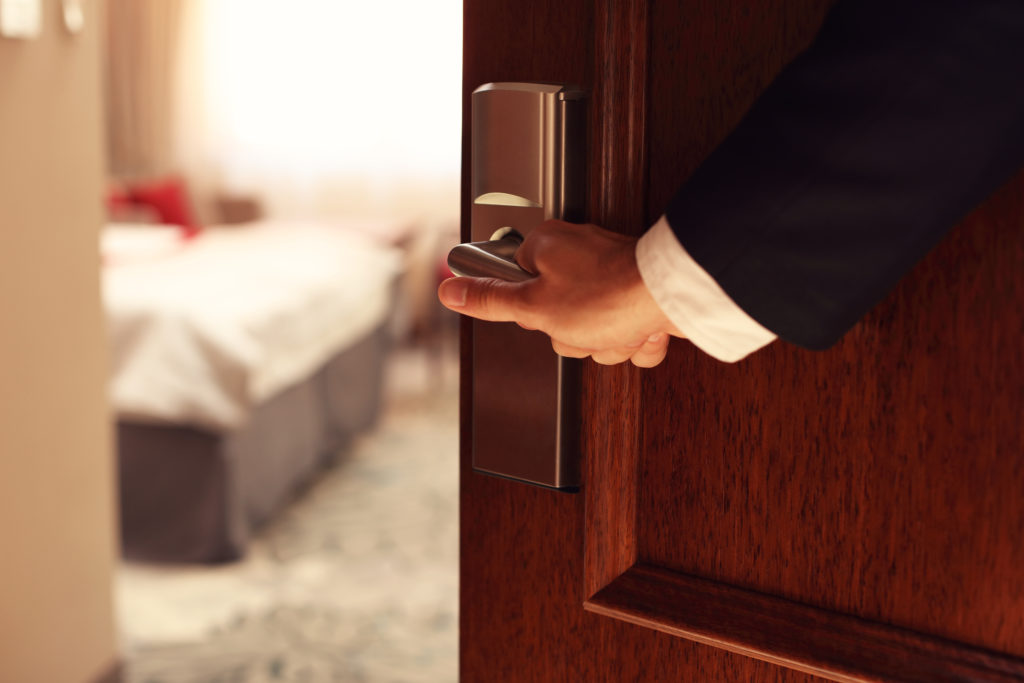 Man holding open hotel room door