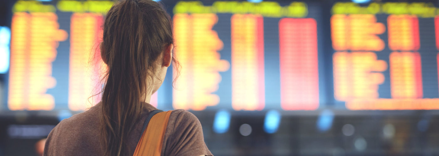 Woman reading departures at departure board