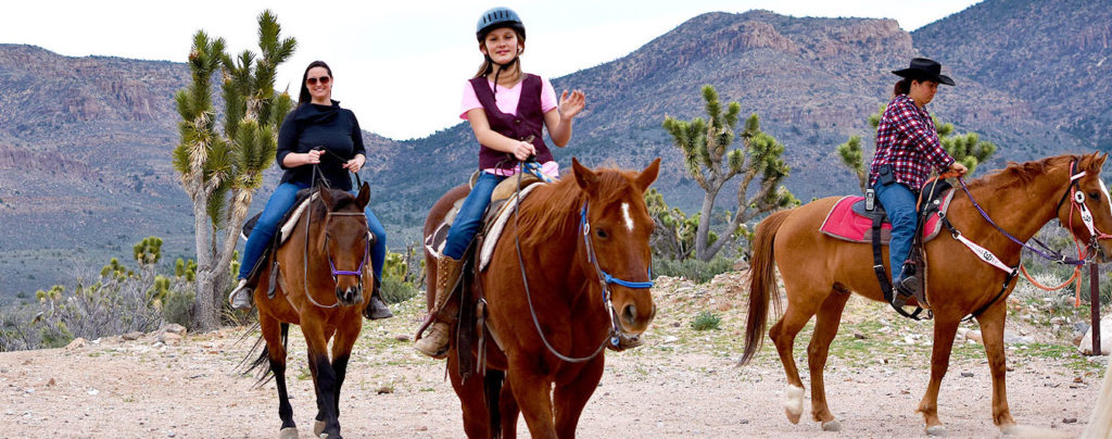 Three people riding horses at the Grand Canyon Western Ranch