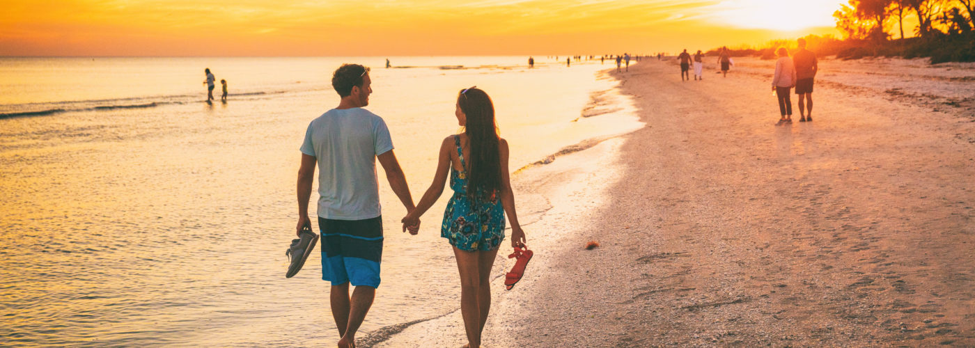 A couple walking along the beach at Sanibel Island, Florida