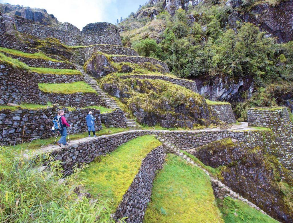 Two hikers walking among Incan ruins