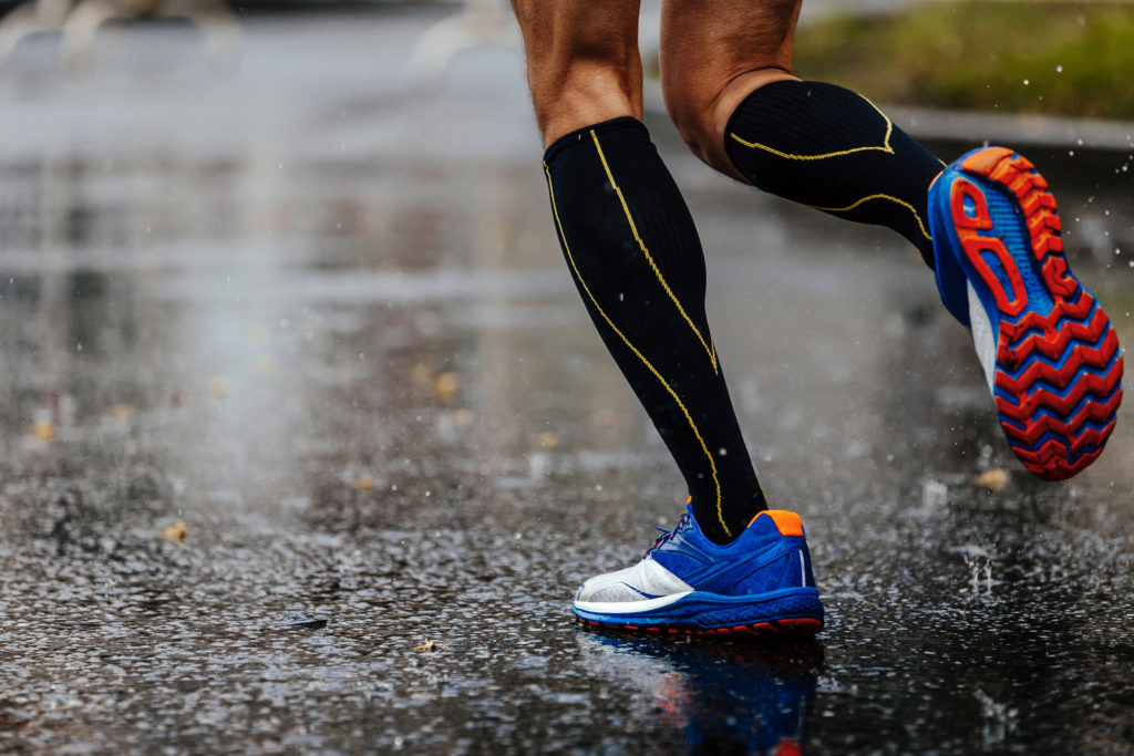 Person running in the rain wearing compression socks