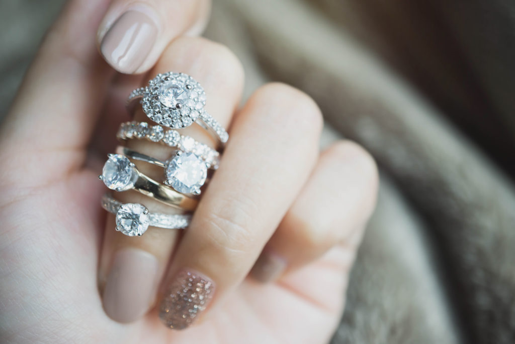 Close up of hand with multiple diamond rings on one finger