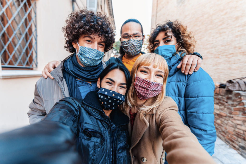 Group of friends taking a selfie while wearing face masks