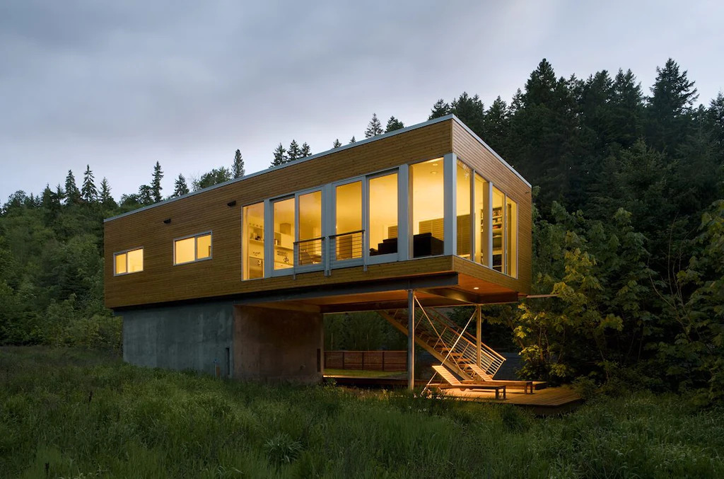Modern cabin with large windows in the middle of forest