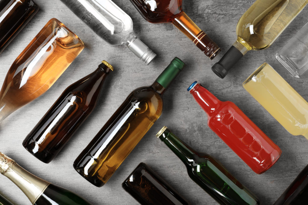Various bottles of alcohol laid out on a grey background