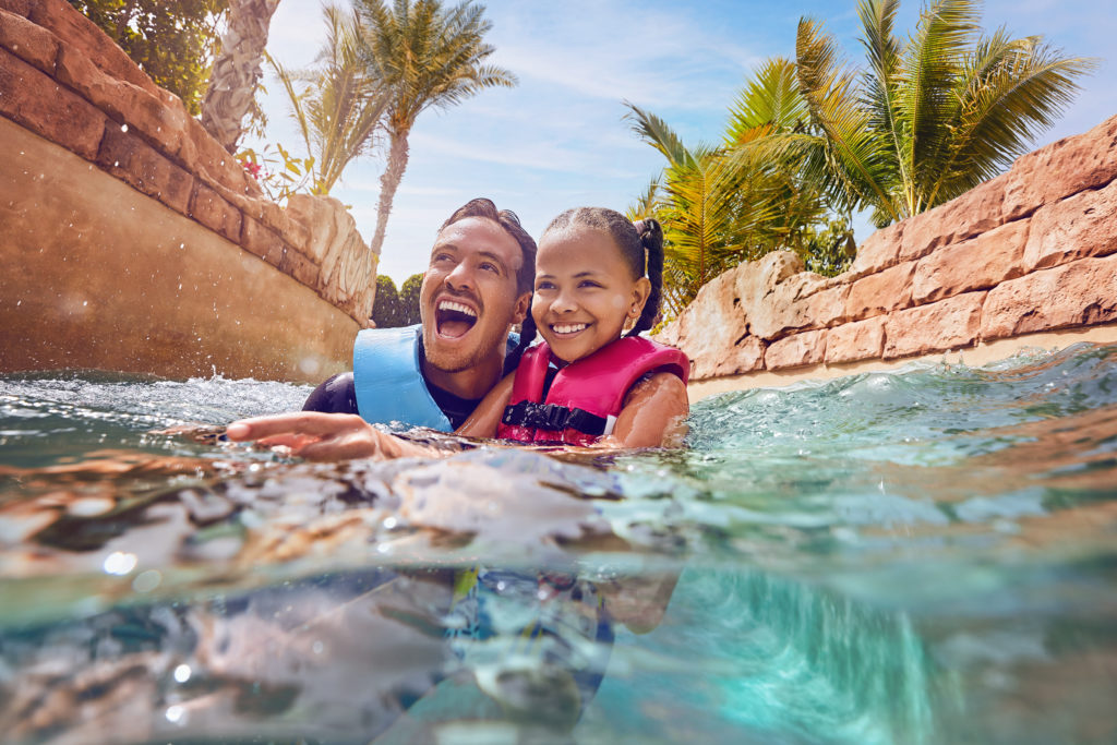 Father and daughter playing in the water at Atlantis, the Palm; Dubai in the United Arab Emirates