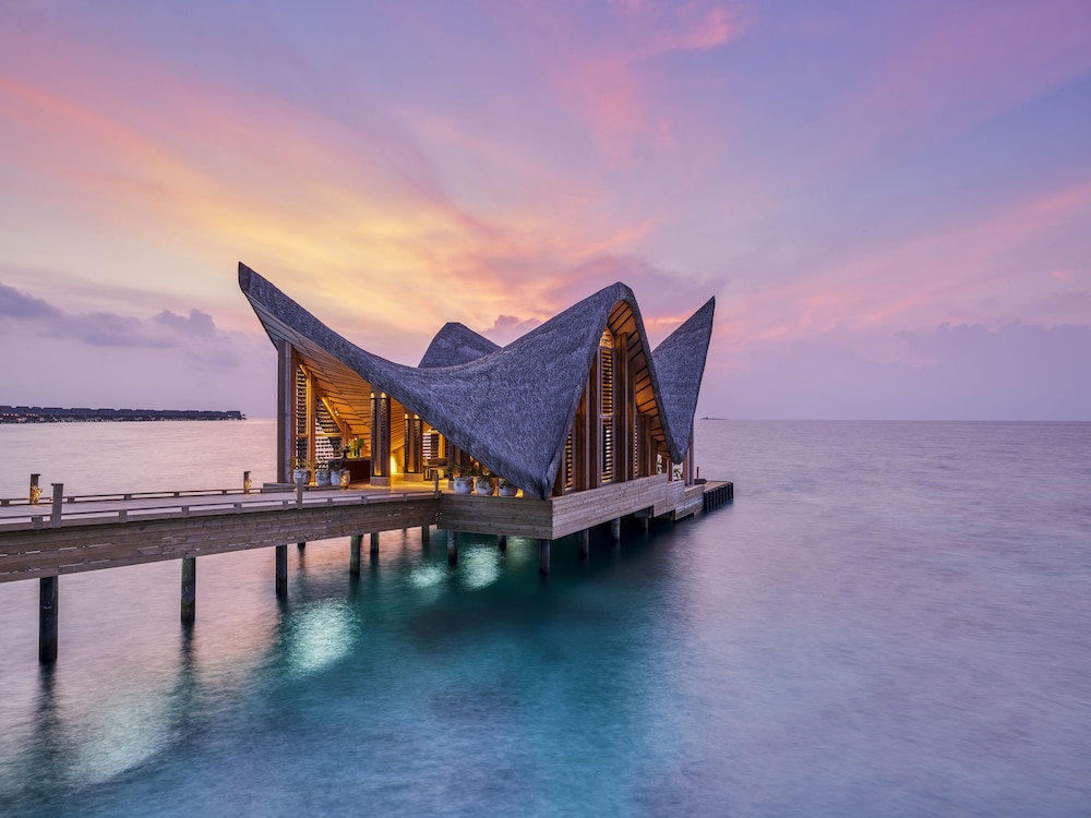 Overwater bungalow at sunset at Joali Maldives