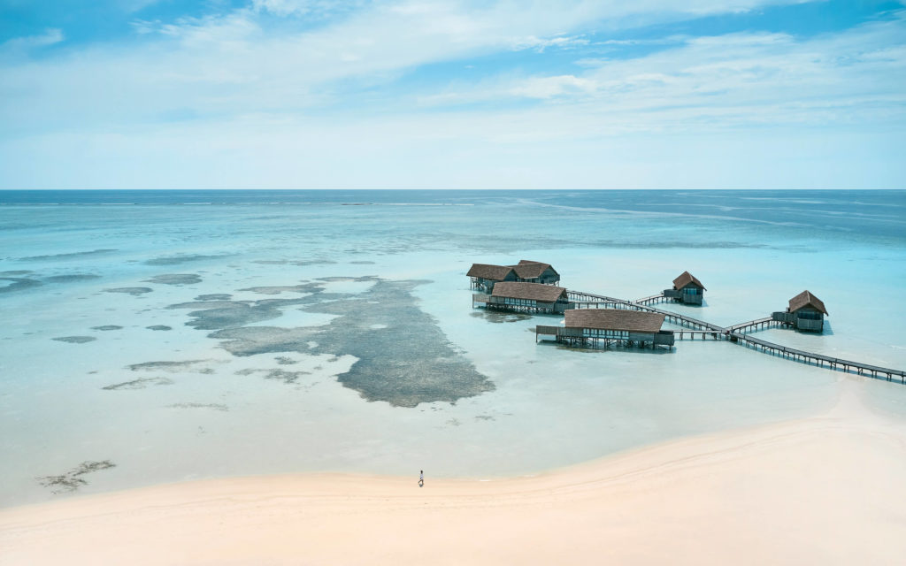 Aerial view of overwater bungalows at Courtesy Cocoa Island By COMO