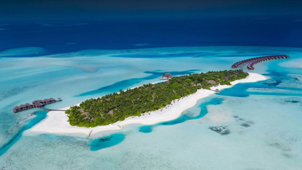 Aerial view of island and overwater bungalows at Anantara Kihavah Villas, Kihavah Huravalhi Island, Maldives