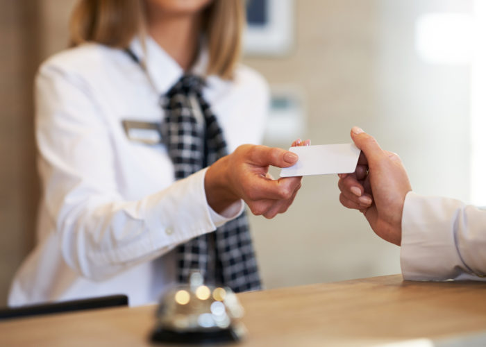 Receptionist handing over a hotel key to a guest