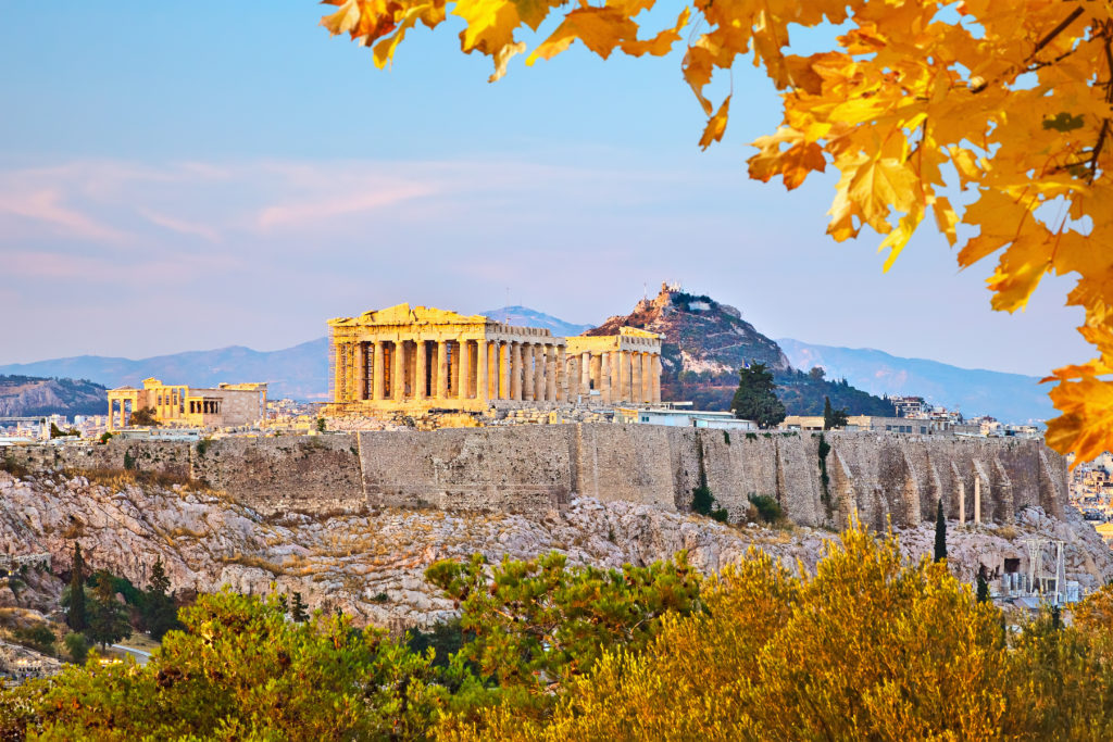 Acropolis at sunset with fall foliage in the foreground in Athens, Greece
